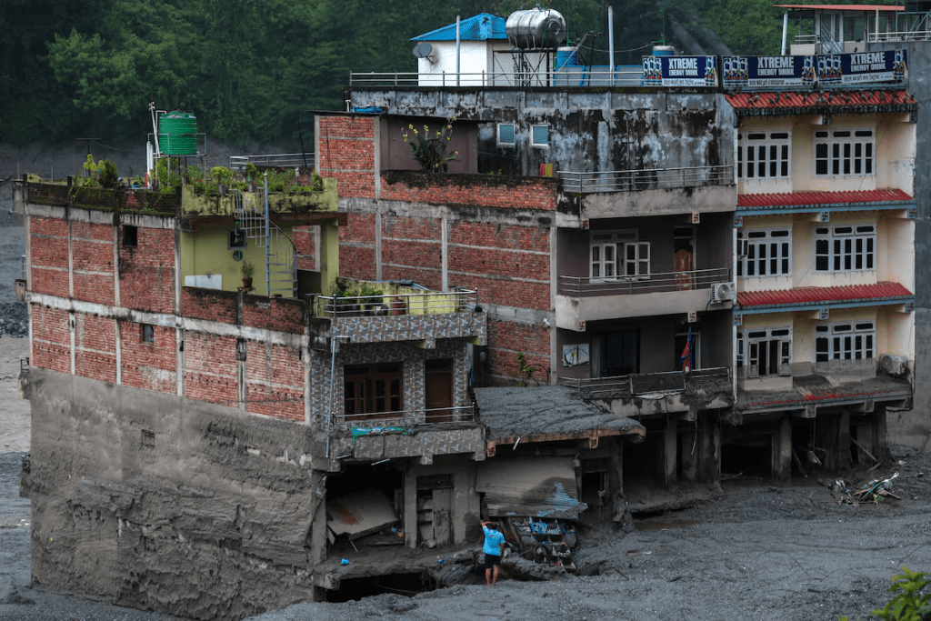 A man stands in front of damaged buildings after flash floods and a mudslide, in Trishuli, Nuwakot district, Nepal, August 29, 2026. REUTERS/Athit Perawongmetha