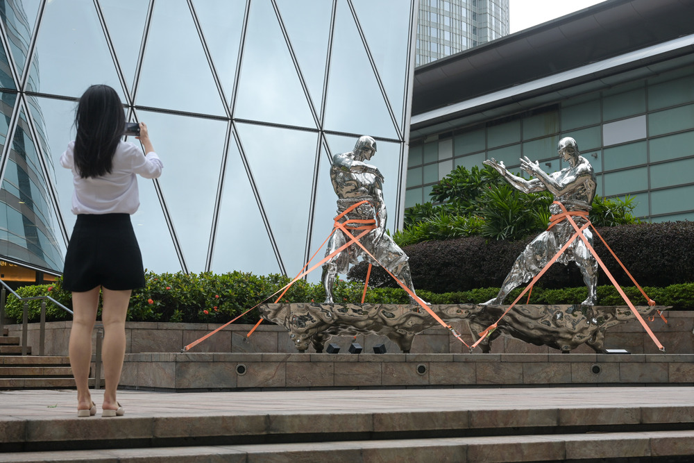 A citizen takes photos of the statues outside Exchange Square tower on July 17, 2023. File photo. A citizen takes photos of the statues outside Exchange Square tower on July 17, 2023. File photo.