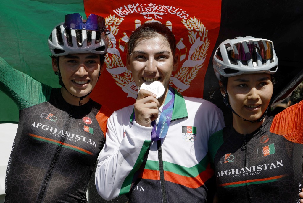 Asian Games - Aichi-Nagoya 2026 - Road Cycling - Women's Road Race - Final - Shinshiro Cycling Road Course, Shinshiro, Japan - September 22, 2026 Silver medallist Afghanistan's Fariba Hashimi celebrates with teammates Yuldoz Hashimi and Zahra Rezayee during the victory ceremony REUTERS/Bryan Foo
