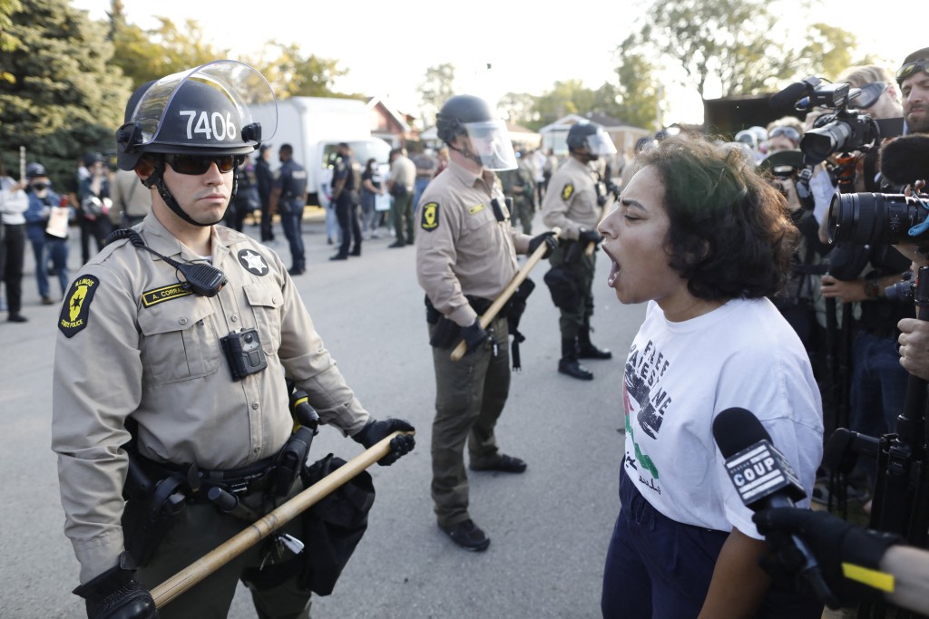  A woman chants slogans in front of law enforcement officers as hundreds of protesters gather near an Immigration and Customs Enforcement (ICE) facility opposing the detention of undocumented immigrants following President Donald Trump’s order to increase federal presence and step up immigration enforcement through the Department of Homeland Security in Broadview, Illinois, on October 3, 2025.  (Photo by OCTAVIO JONES / AFP)