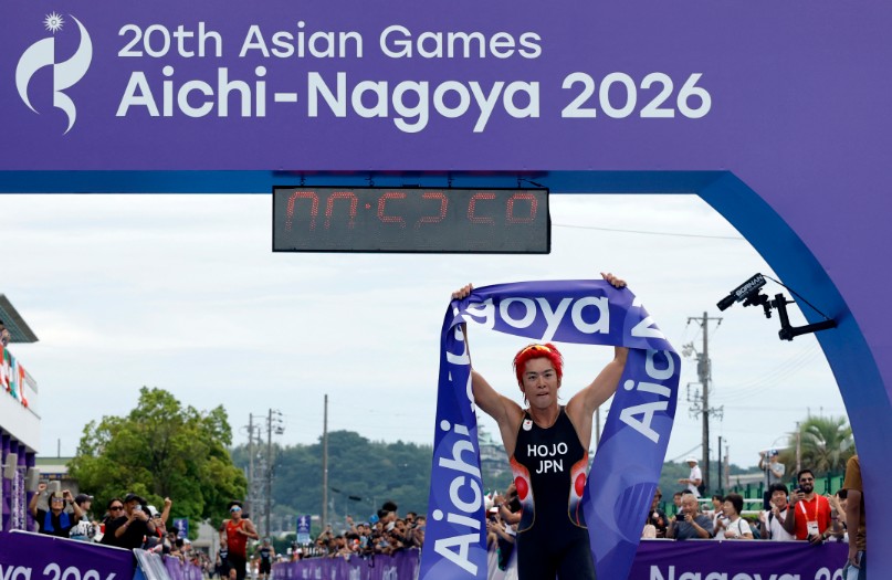 Japan's Takumi Hojo celebrates as he crosses the line to win the gold medal in men's triathlon.  REUTERS