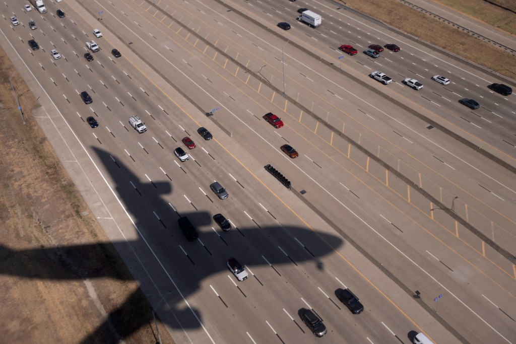 Photo by BRENDAN SMIALOWSKI / AFP  The shadow of Air Force One is seen over a freeway as the presidential aircraft lands at Dallas-Fort Worth International Airport in Irving, Texas, on September 9, 2026.