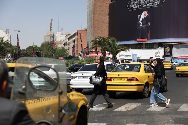 People walk past a billboard with a picture of the Iran's late Supreme Leader Ayatollah Ali Khamenei, in Tehran, Iran, June 17, 2026. Majid Asgaripour/WANA (West Asia News Agency) via REUTERS