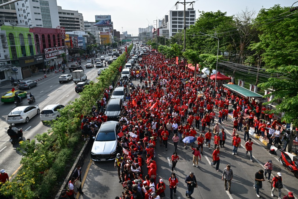 Supporters of Thailand's former prime minister Thaksin Shinawatra gather around his car as he leaves after his release from Klong Prem Central Prison in Bangkok on May 11, 2026. (AFP)