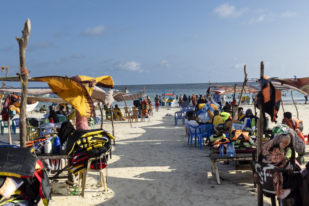 Photo by TONY KARUMBA / AFP  Vendors hawking food and flotation devices wait for visitors at Lido beach in Mogadishu on November 10, 2025.