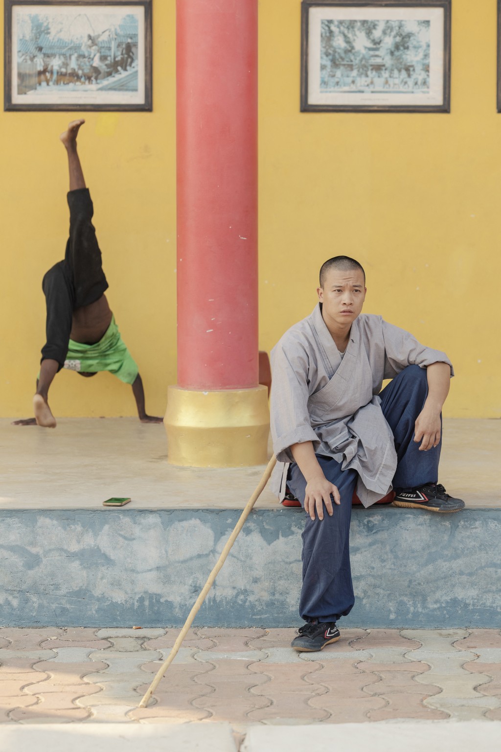 Photo by GIANLUIGI GUERCIA / AFP  Shaolin monk Yan Chen helps student to somersault during a training session at a Shaolin Temple outside Lusaka, on August 8, 2026.