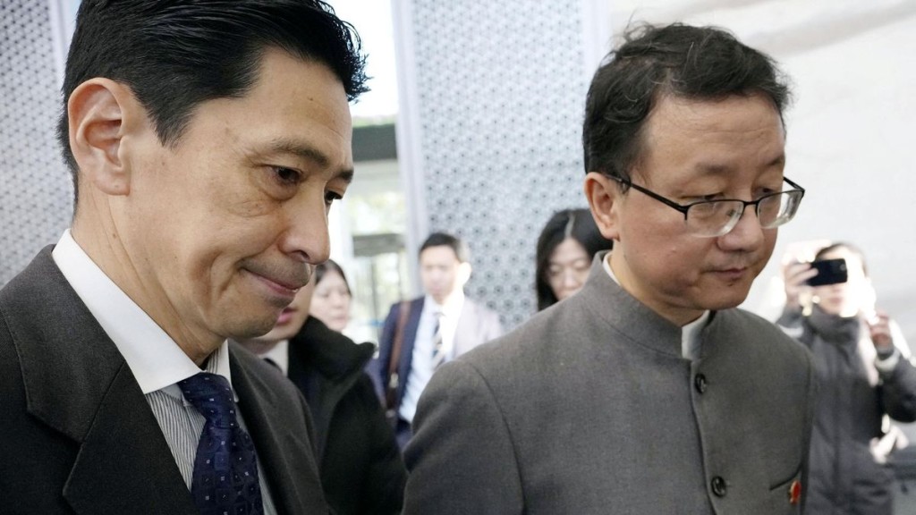 Masaaki Kanai (left) talks with Liu Jinsong on the day of their meeting in Beijing. Reuters