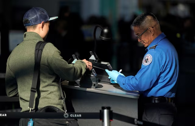 An employee with the Transportation Security Administration (TSA) checks the documents of a traveler at Reagan National Airport in Washington, U.S., January 6, 2019. REUTERS/Joshua Roberts