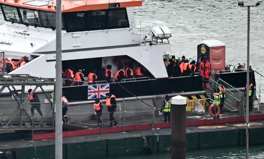 Migrants picked up at sea attempting to cross the English Channel from France, disembark from Border Force vessel 'Typhoon' after it arrived at the Marina in Dover, southeast England, on January 13, 2025. The first migrant was deported from the UK to France on Thursday, September 18, as part of the migration agreement reached this summer between the two countries, the British Home Office confirmed. (Photo by Ben STANSALL / AFP)
