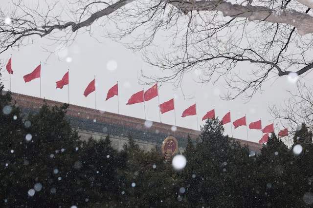 Chinese national flags flutter on top of the Great Hall of the People amid snowfall ahead of the opening session of the Chinese People's Political Consultative Conference (CPPCC) in Beijing, China, March 4, 2026. REUTERS/Go Nakamura/ File Photo 