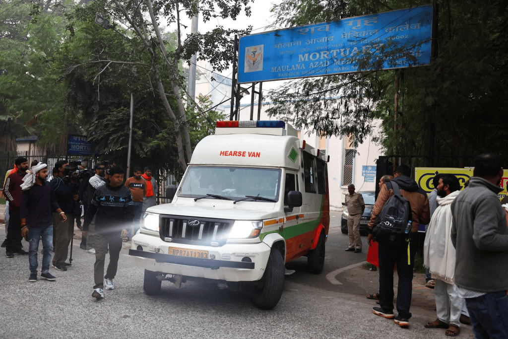 People stand next to a hearse van carrying the body of a person, who died in a deadly explosion near the historic Red Fort in the old quarters of Delhi, outside a mortuary at a hospital, in Delhi, India, November 11, 2025. REUTERS/Anushree Fadnavis