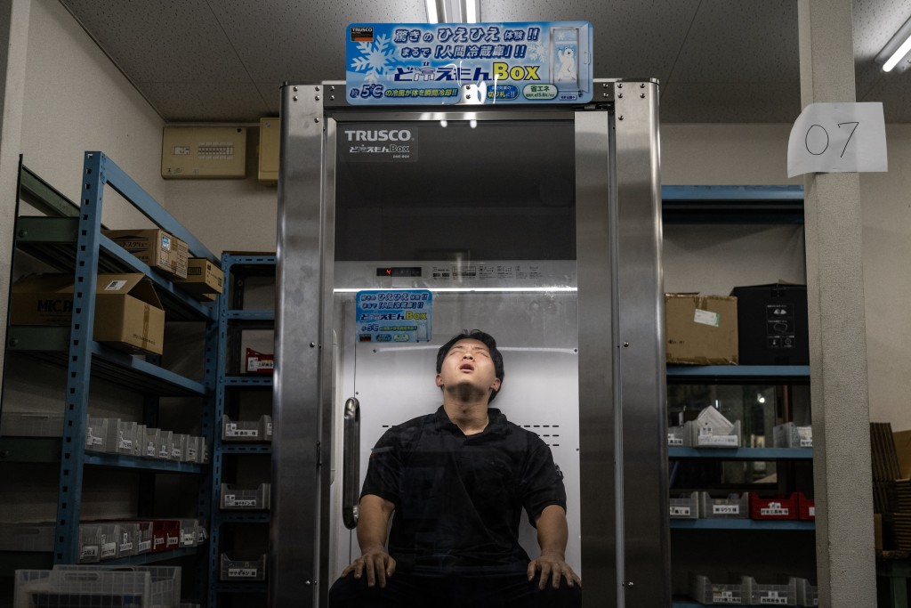 Photo by ANDREW CABALLERO-REYNOLDS / AFP  Konoe employee Taichi Konishi takes a break in a cooling box for workers also known as a "human fridge" at the company's warehouse, a specialist wholesaler of screws and surveying equipment, on a hot day in Higashiosaka, Osaka Prefecture on August 21, 2026.