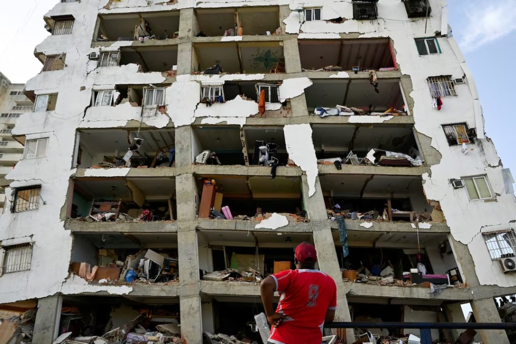 A man looks at a damaged building in the aftermath of earthquakes in La Guaira, Venezuela, June 25, 2026. REUTERS/Maxwell Briceno