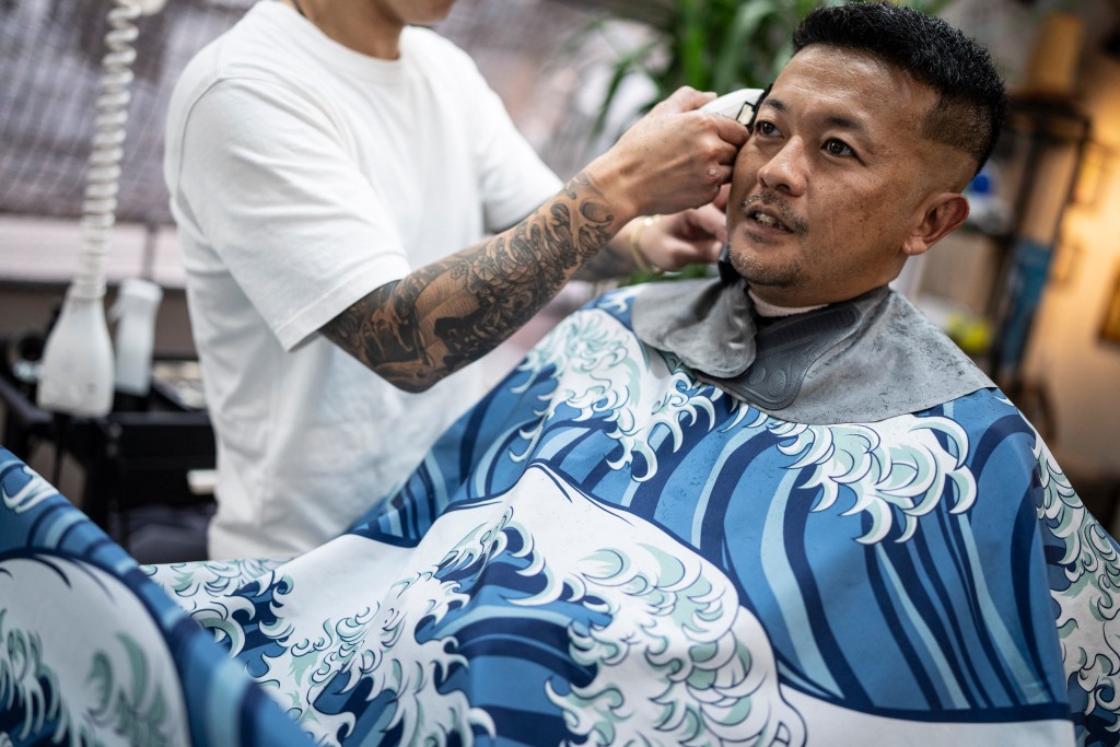 Photo by YUICHI YAMAZAKI / AFP  This photo taken on August 27, 2026 shows Tekisasu, an active yakuza gangster allied to a major clan, having his hair cut at a barbershop in Tokyo.