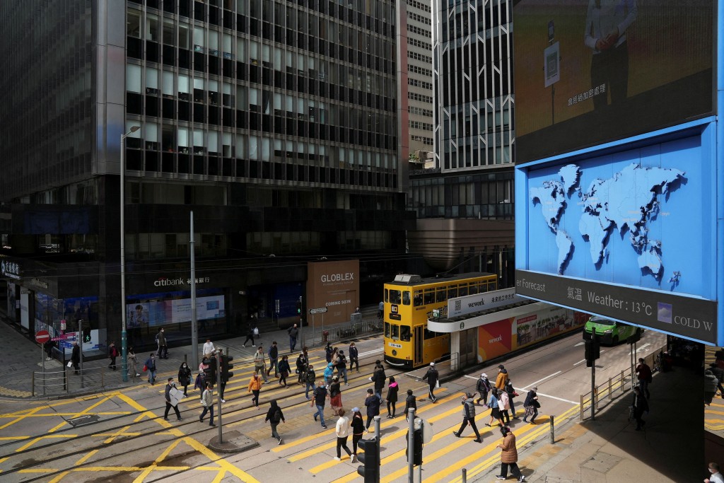 FILE PHOTO: Pedestrians walk on a crossing at the Central district in Hong Kong, China February 23, 2022. REUTERS/Lam Yik/File Photo
