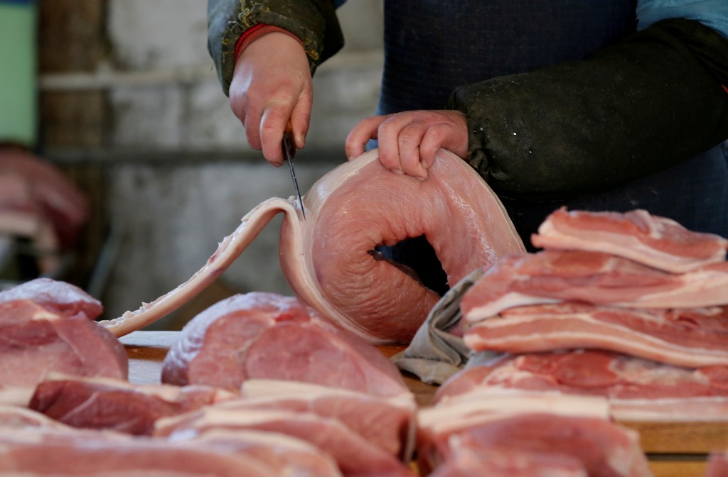 A butcher cuts a piece of pork at a market in Beijing, China, March 25, 2016. REUTERS/Jason Lee/File Photo