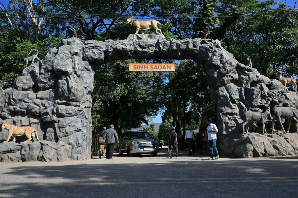 Photo by INDRANIL MUKHERJEE / AFP  This photograph taken on November 10, 2025 shows visitors walking past the entrance of the Gir National Park in India's western state of Gujarat.