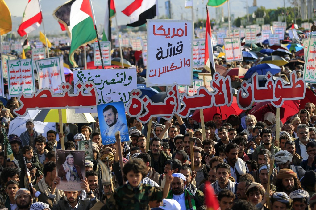 Israel declared a ceasefire and started pulling back troops in Gaza on October 10, as thousands of displaced Palestinians began to make their way back to their wrecked homes. Supporters of Yemen's Huthis raise placards and flags as they gather to celebrate the ceasefire in the Gaza Strip, in Sanaa on October 10, 2025.  Photo by MOHAMMED HUWAIS / AFP