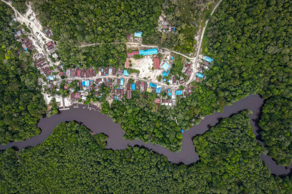 Photo by BAY ISMOYO / AFP  This aerial picture taken on February 11, 2026 shows Humbang Raya village located along a river and the forest in Kapuas Regency in Indonesia's Central Kalimantan Province.