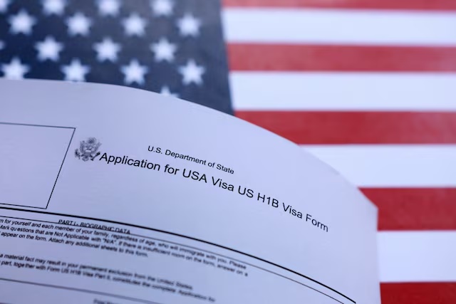 U.S. flag and U.S. H-1B Visa application form are seen in this illustration taken September 26, 2025. REUTERS/Dado Ruvic/Illustration