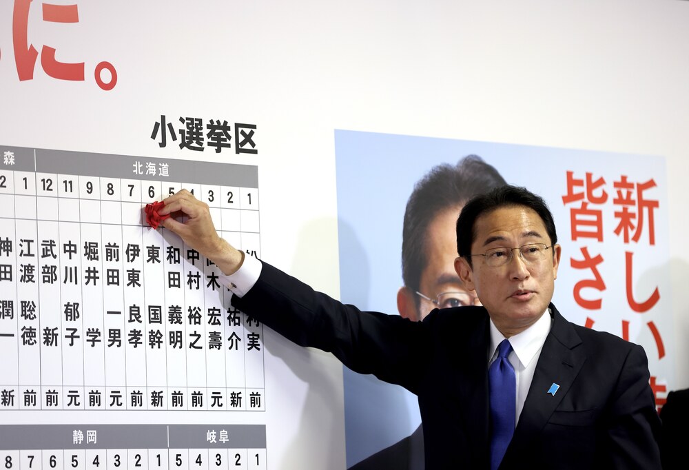 Japan's Prime Minister and ruling Liberal Democratic Party leader Fumio Kishida puts rosettes by successful general election candidates' names on a board at the party headquarters in Tokyo, Sunday, Oct. 31, 2021. (AP) Japan's Prime Minister and ruling Liberal Democratic Party leader Fumio Kishida puts rosettes by successful general election candidates' names on a board at the party headquarters in Tokyo, Sunday, Oct. 31, 2021. (AP)