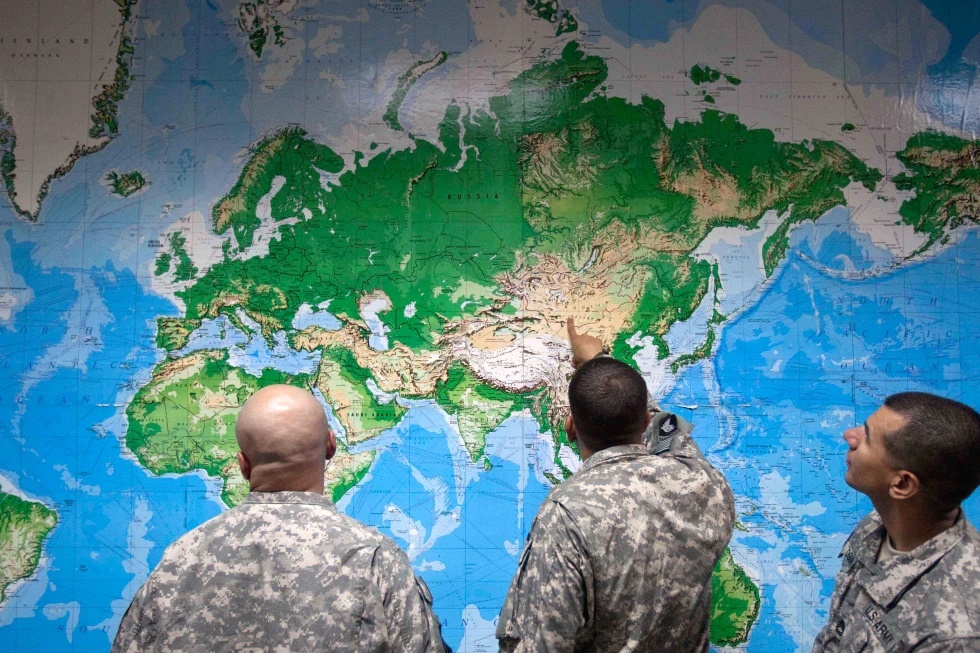 Soldiers look at a world map as they wait to board a flight in Manas, Kyrgyzstan, on the way home after completing a deployment in Afghanistan, Thursday, Aug. 11, 2011. (AP Photo/David Goldman, file)
