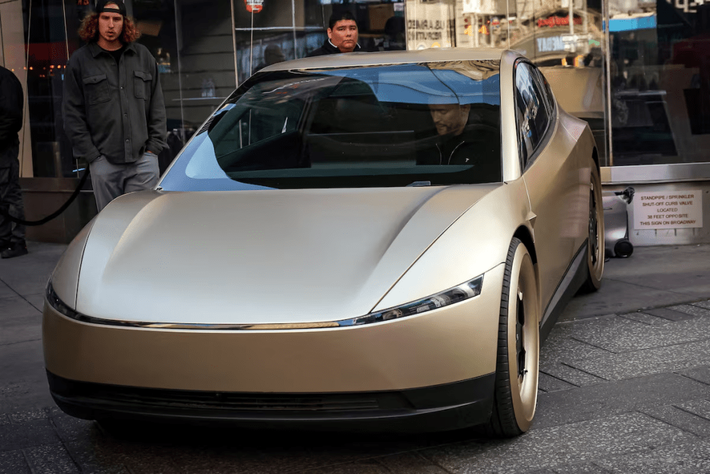 A person sits in a Tesla Cybercab outside the Nasdaq Market site in New York City, U.S., October 27, 2025. REUTERS/Brendan McDermid/File Photo