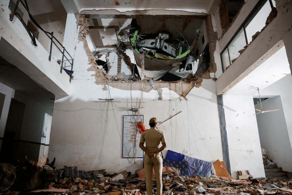 A police officer stands in front of the wreckage of an Air India aircraft, bound for London's Gatwick Airport, which crashed during take-off from an airport in Ahmedabad, India June 12, 2025. REUTERS/Adnan Abidi/File Photo