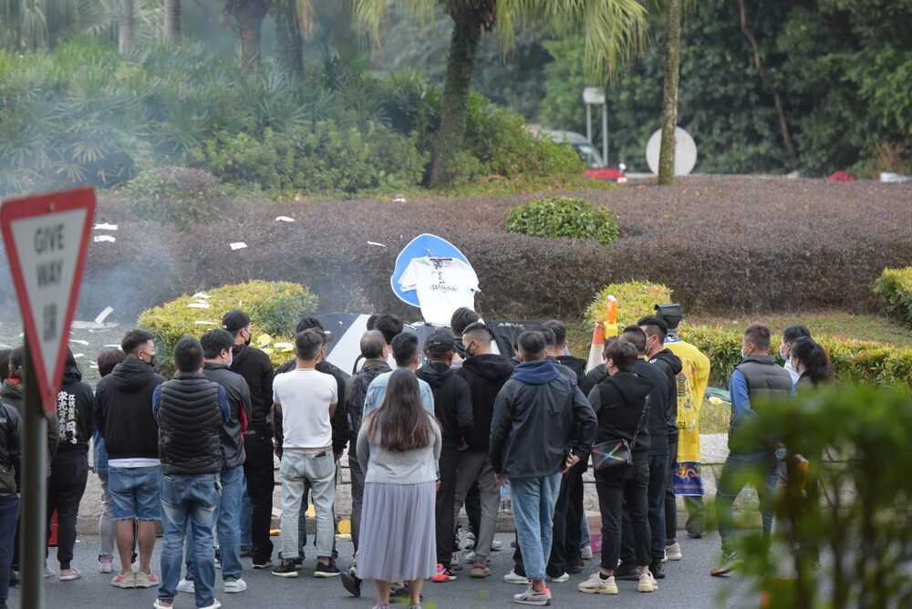 Family members of the deceased driver arrived at the scene for a roadside tribute. 