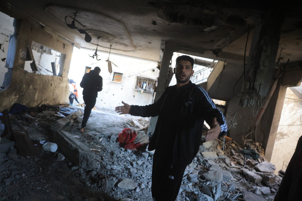 Photo by BASHAR TALEB / AFP  APalestinian man reacts as he inspects a destroyed house after an Israeli military attack on the home of the al-Houli family, in which four people were reportedly killed, west of Deir al-Balah, in the central Gaza Strip on January 16, 2026.