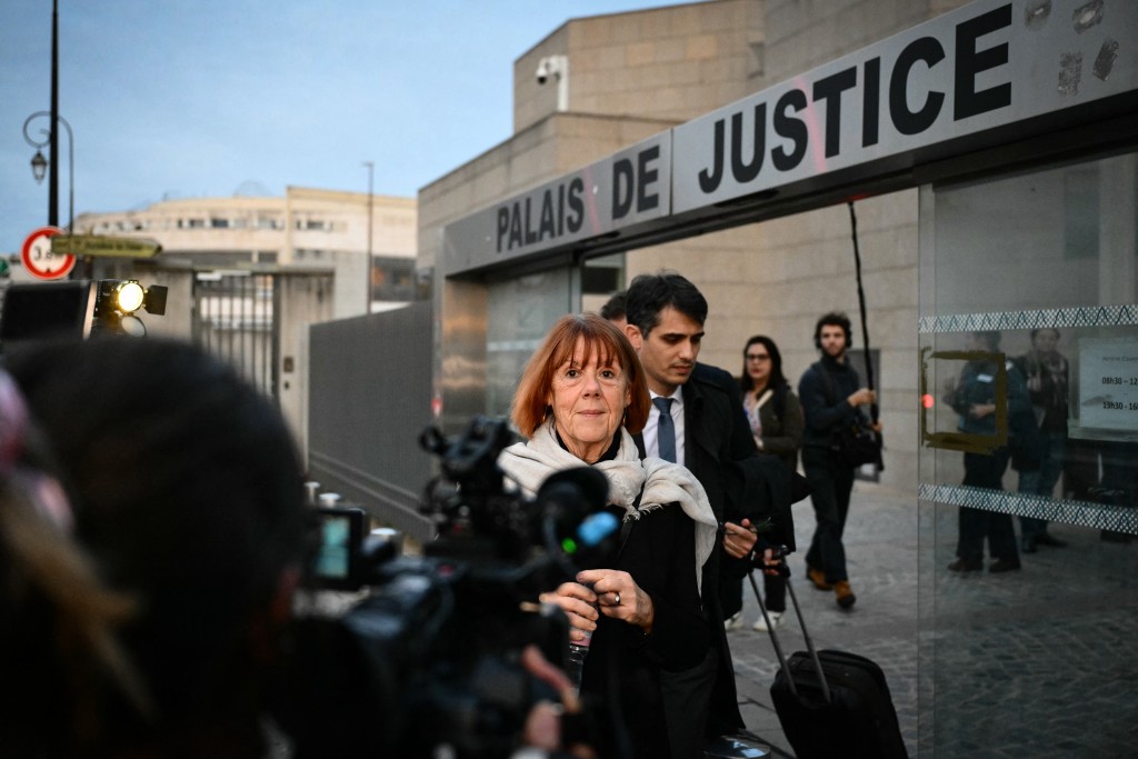 (FILES) Gisele Pelicot (C) leaves Avignon courthouse after a hearing as part of the trial of her former partner Dominique Pelicot accused of drugging her for nearly ten years and inviting strangers to rape her at their home in Mazan, a small town in the south of France, in Avignon, on November 26, 2024. (Photo by Christophe SIMON / AFP)