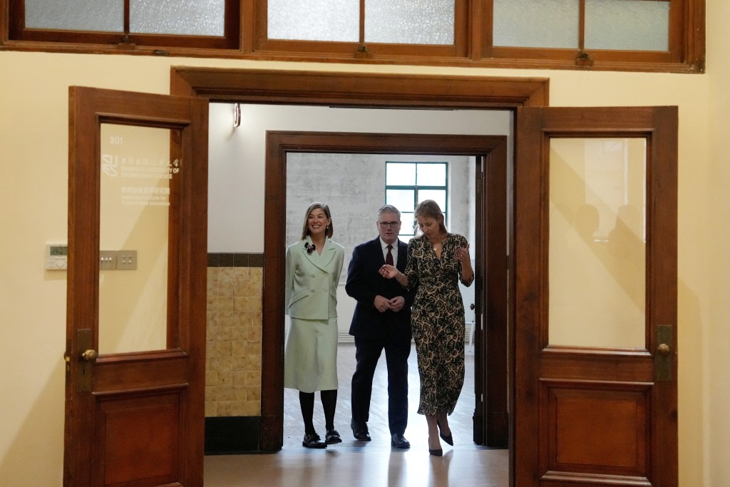 Britain's Prime Minister Keir Starmer (C), British actor-producer Rosamund Pike (L) and National Theatre London co-CEO Kate Varah (R) arrive to meet with Chinese performing arts students at the Design Innovation Institute Shanghai, in Shanghai on January 31, 2026. (Photo by Kin Cheung / POOL / AFP)