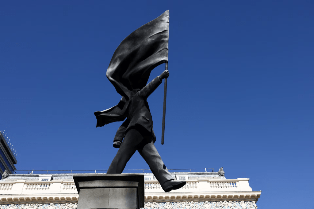 A statue depicting a person stepping off the plinth while carrying a flag covering their face, by British street artist Banksy, stands in London, Britain, April 30, 2026. REUTERS/Jack Taylor