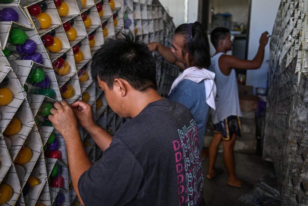 Photo by JAM STA ROSA / AFP  This photo taken on December 4, 2025, shows men working on a giant lantern in San Fernando, Pampanga, in preparation for the Giant Lantern Festival.
