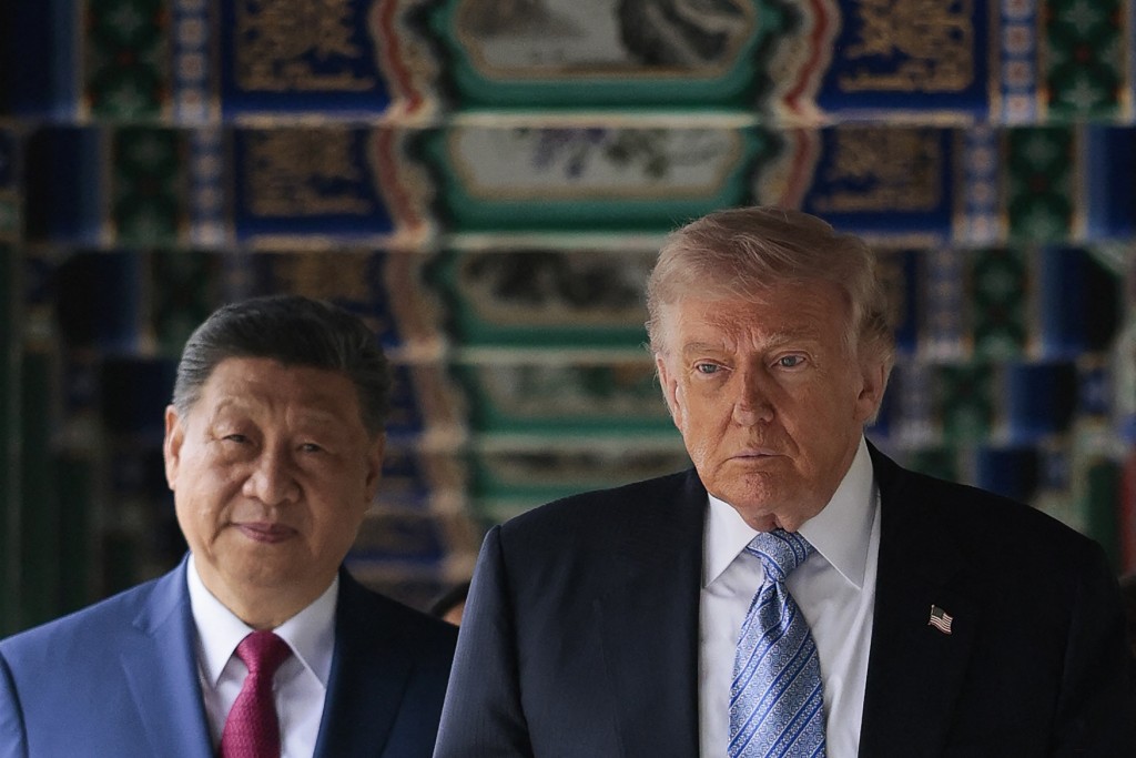 US President Donald Trump (R) walks with China’s President Xi Jinping (L) at Zhongnanhai Garden in Beijing on May 15, 2026. (Photo by Evan Vucci / POOL / AFP)