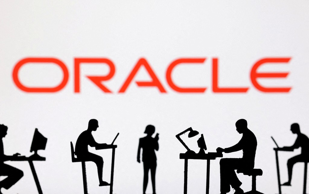 Figurines with computers and smartphones are seen in front of Oracle logo in this illustration taken, February 19, 2024. REUTERS/Dado Ruvic