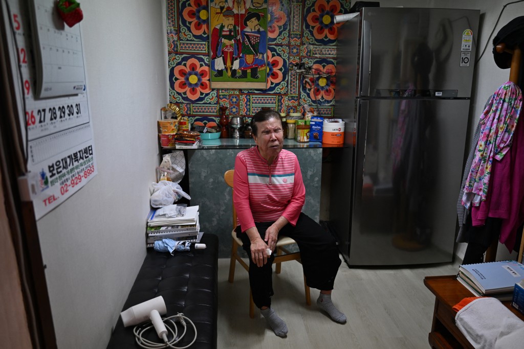 Photo by GREG BAKER / AFP  In this photo taken on July 29, 2026, blind fortune-teller Song Oh-soon speaks at her small practice in the “Mia-ri fortune-telling village” in Seoul.