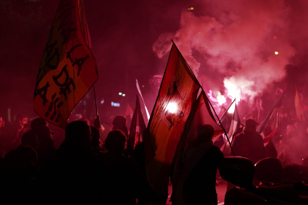 Photo by THOMAS COEX / AFP. Demonstrators carry flags and light up flares during a demonstration called by Falange Espanola de las JONS fascist party in Madrid, on November 21, 2025, marking the 50th anniversary of Spanish dictator Francisco Franco's death.
