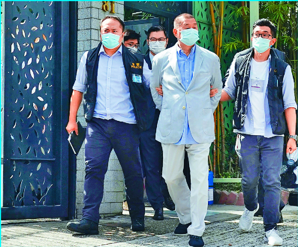 Jimmy Lai is led away in handcuffs from his home in Ho Man Tin before being taken to Next Media headquarters in Tseung Kwan O, which was searched by more than 200 police officers.Agencies, Sing Tao