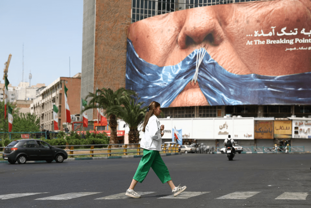 A woman walks past an anti-U.S. billboard depicting U.S. President Donald Trump and the Strait of Hormuz, in Tehran, Iran. Majid Asgaripour/WANA (West Asia News Agency) via REUTERS 