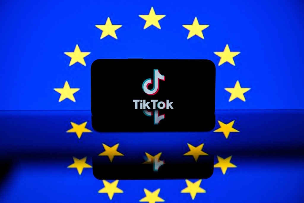 This photograph shows a screen displaying the Tiktok social media platform's logo and the European flag in Toulouse, south-western France on April 26, 2023. An Irish regulator helping police European Union data privacy said July 10, 2025, that it had launched an investigation into TikTok over the transfer of European users' personal data to servers in China. (Photo by Lionel BONAVENTURE / AFP)