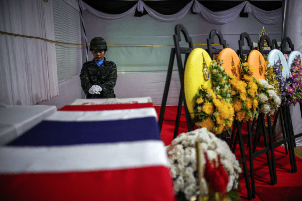 A soldier salutes next to a coffin of Sergeant Major Ananda Udon, 39, a Thai soldier who died on December 10 amid clashes between Thailand and Cambodia along a disputed border area, during his funeral at a temple in Si Sa Ket province, Thailand, December 12, 2025. (REUTERS/Athit Perawongmetha)