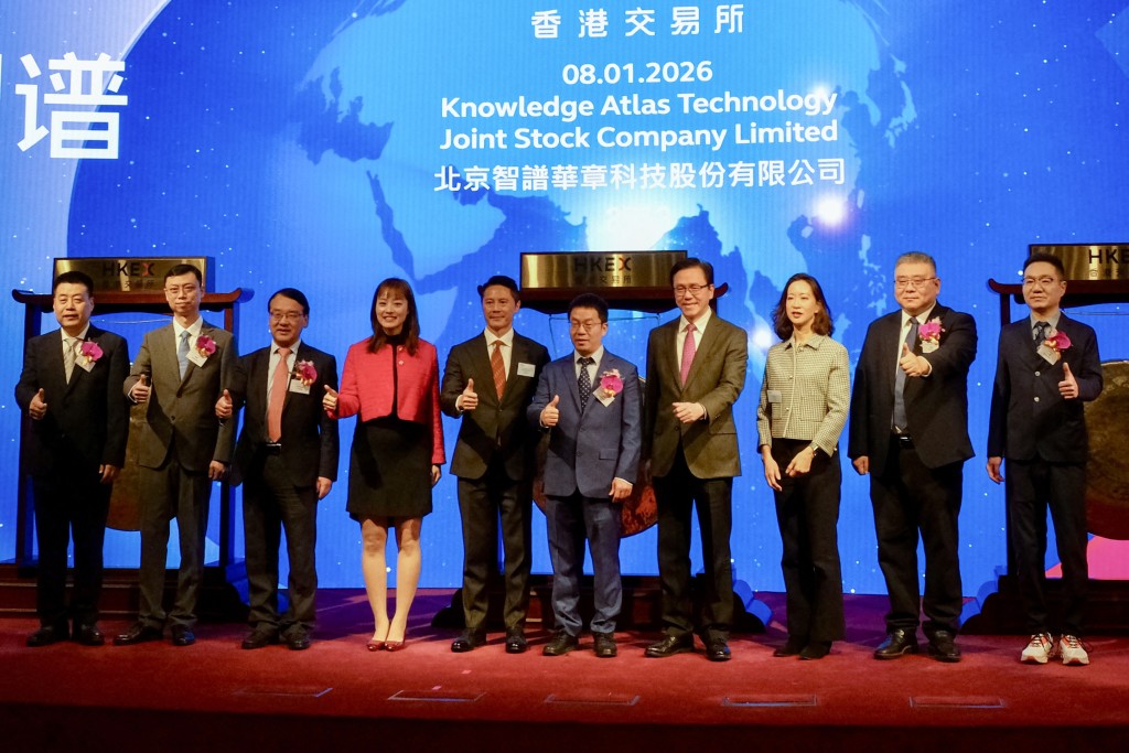 Photo by TOMMY WANG / AFP  Company chairman Liu Debing (5th R) and attendees pose during the initial public offering (IPO) launch of one of the largest large language model developers in China, Zhipu AI, or Knowledge Atlas Technology, at the Hong Kong Stock Exchange (HKEX) on January 8, 2026.