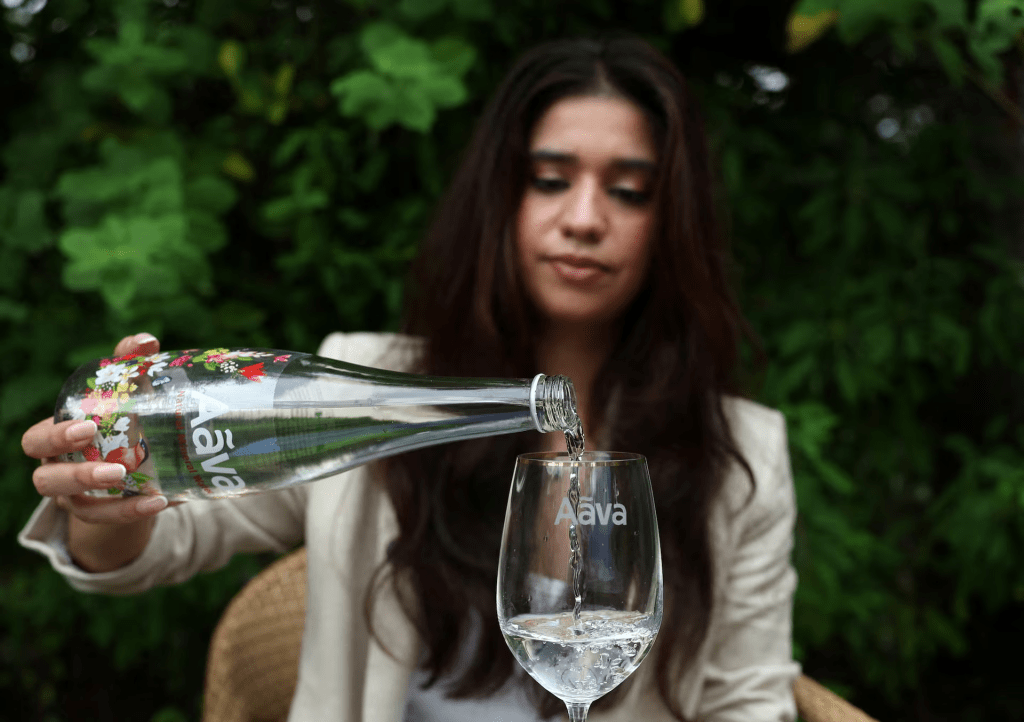 Avanti Mehta, 32, India's youngest water sommelier, fills a glass with Aava Natural mineral water in Ahmedabad, India, October 2, 2025. REUTERS/Amit Dave