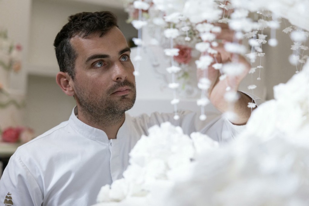 Photo by THOMAS SAMSON / AFP French pastry chef Bastien Blanc-Tailleur decorates a wedding cake at his studio in Saint-Remy-les-Chevreuse, southwestern Paris on April 10, 2026.