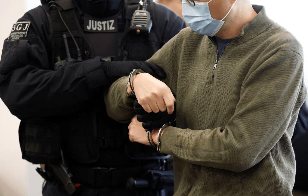 Defendant Jian G., a former assistant to then-member of the European Parliament Maximilian Krah, of the far-right Alternative for Germany (AFD) party, is getting uncuffed as he arrives at the courtroom for a high-profile espionage trial, in Dresden, Germany, on September 30, 2025. ODD ANDERSEN/Pool via REUTERS