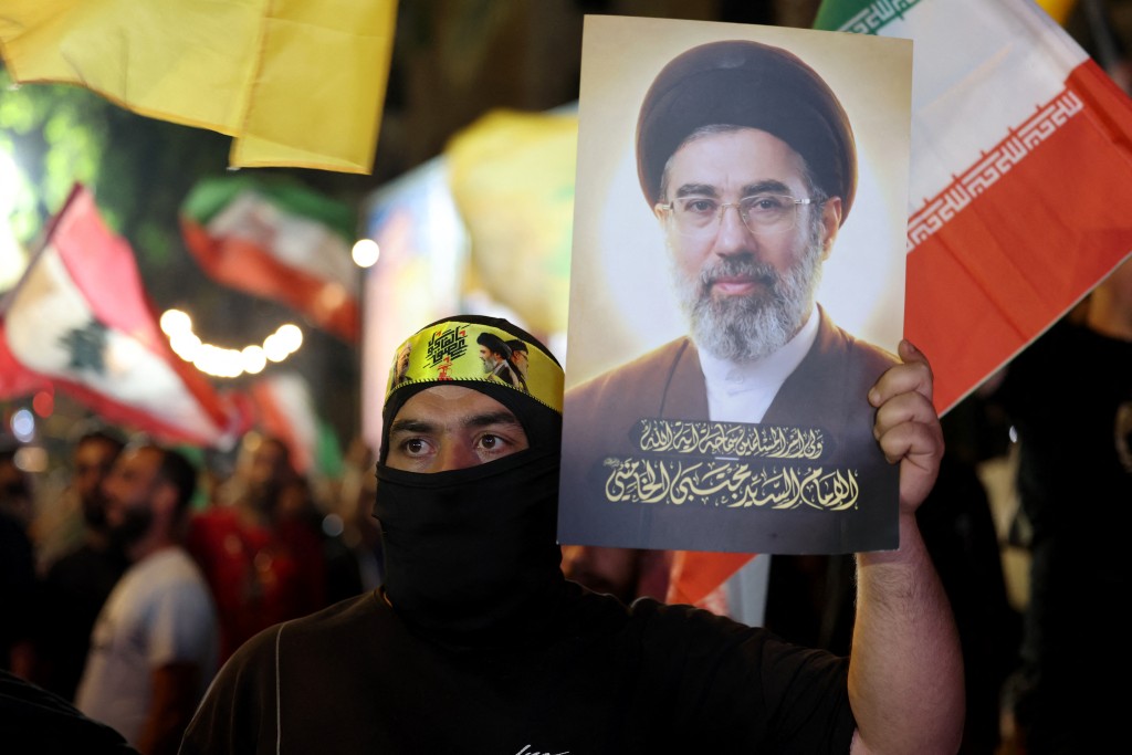 Photo by ANWAR AMRO / AFP A supporter of Iran-backed armed group Hezbollah, holds a portrait of Iran's supreme leader Mojtaba Khamenei during an anti-US and anti-Israel protest organised by the International Popular Committees to Resist Aggression in Beirut’s southern suburbs on June 10, 2026.