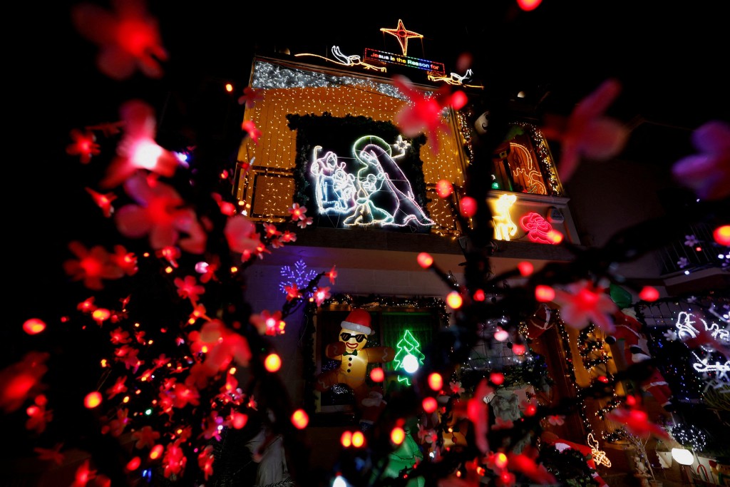 The facade and front garden of a house are covered in Christmas lights and decorations in San Gwann, Malta December 17, 2025. REUTERS/Darrin Zammit Lupi 