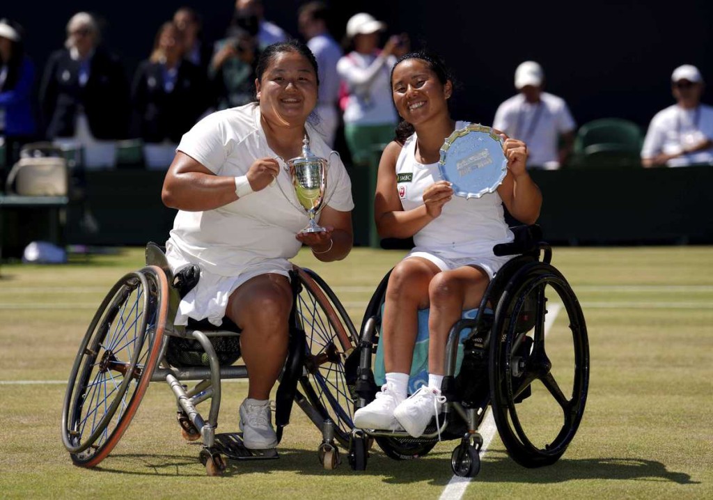 Wang Ziying of China celebrates, left, with the trophy after beating Yui Kamiji of Japan, right, to win the final women’s wheelchair singles match at the Wimbledon Tennis Championships in London, Saturday, July 12, 2025. (AP)
