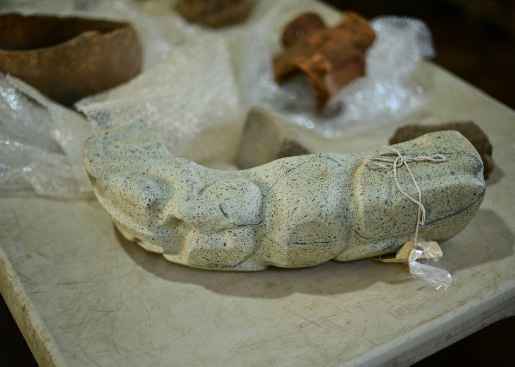 Photo by MARCO ANTONIO MARTINEZ / AFP  A green stone “yoke” depicting a batrachian is seen among objects found at an archaeological site and undergoing classification and documentation in Coatepec, Veracruz, Mexico on June 18, 2026.